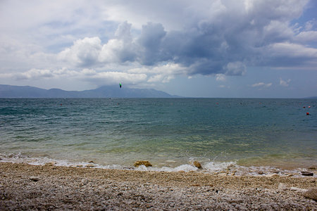 Seascape. Blue sea, pebble beach and mountains on the horizonの写真素材