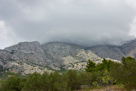 Mountain scenery. High mountains with peaks covered by cloudsの写真素材