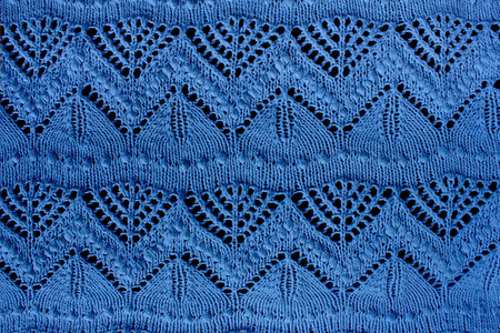 Textured blue openwork close-up knitted on needles. Blue patterned backgroundの写真素材