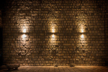 Background old stone wall close-up with three lamps and the floorの写真素材