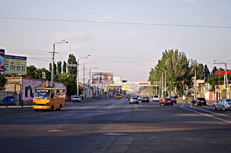 Odessa, Ukraine - AUGUST 05, 2017: An evening city, a stream of cars on the wide highway, yellow route taxis, billboards with advertisements of various goods and phones, along the road.のeditorial素材
