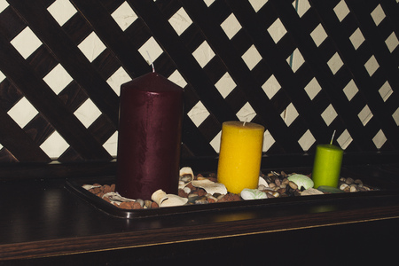 Photo of three candles of various sizes of green, yellow and red as a decor elementの写真素材