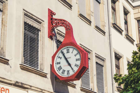 RIESA/GERMANY - July 23/2018: Photo of big red vintage clock on the wall of a houseのeditorial素材