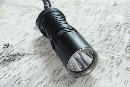 led flashlight laying on birch bark