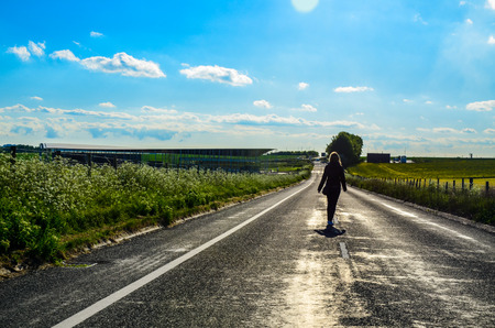 Silhouette of a woman walking on a road in the countrysideのeditorial素材