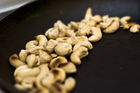 Toasted cashew nuts in a frying panの写真素材
