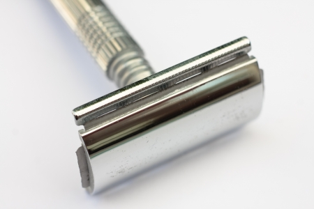 A chrome plated double edged safety razor on a white backgroundの写真素材