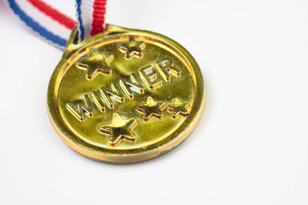 A children's plastic gold winners medal on a white backgroundの写真素材