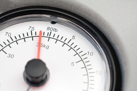 Close-up of a dial from a set of scales showing imperial and metric units