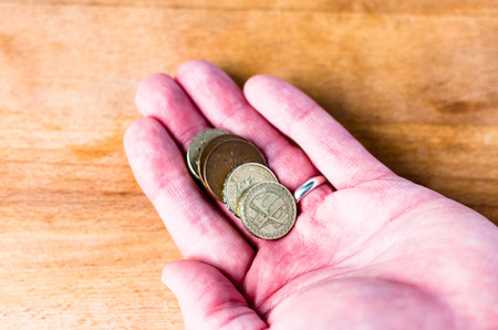 An adult male hand holding some loose changeの写真素材