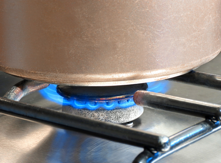 Saucepan being heated on a gas hob                          の写真素材