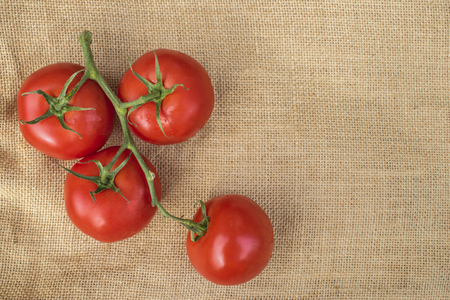 Fresh ripe healthy Vine Tomatoes on a hessian materialの写真素材