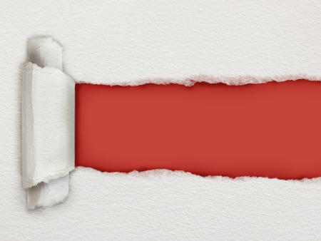 Torn piece of watercolour paper revealing a red background for copy spaceの写真素材