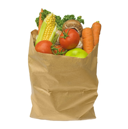 Healthy fruit and vegetables in a brown paper bag, isolated on a white backgroundの写真素材