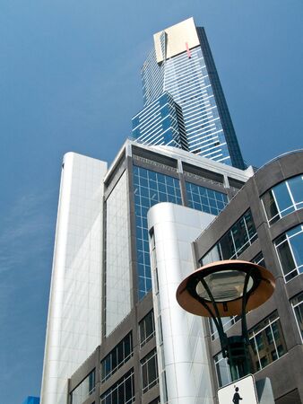 A collection of tall modern buildings looking skywards.  Shot against a blue sky, with fine cloudの写真素材