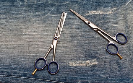 Hairdressing scissors on the blue jeans backgroundの写真素材