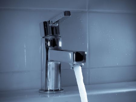 Stream of water flowing from faucet in bathroom の写真素材