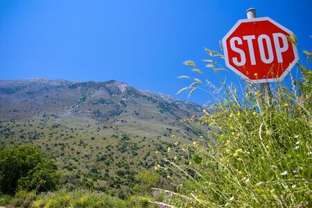 Road sign "Stop" on a backgrond mountain landscapeの写真素材