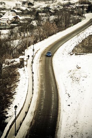 Small car on a winter winding roadの写真素材