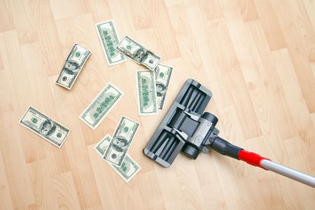 Vacuum cleaner cleaning monetary dust on the floorの写真素材