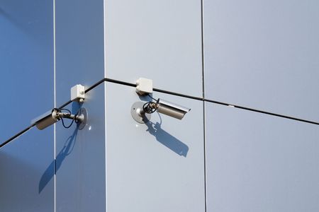 A security cameras on the side of an office building.の写真素材