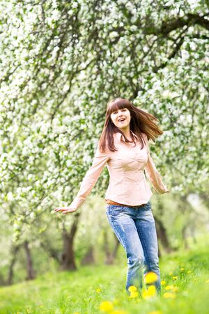 Happy young woman in the blooming gardenの写真素材