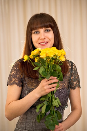 Young woman holding the bunch of yellow rosesの写真素材