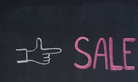 Hand pointing to the word Sale, written on a blackboardの写真素材