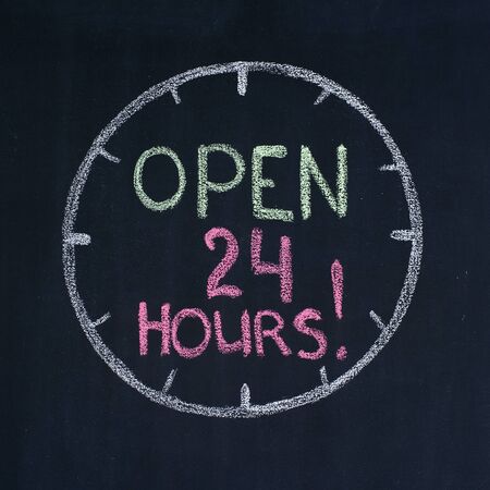The dial with text Open 24 hours, drawn on a blackboardの写真素材