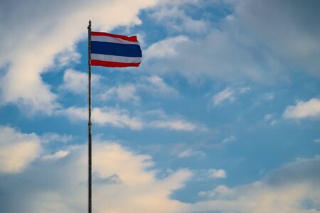 National flag of Thailand on the cloudy sky backgroundの写真素材