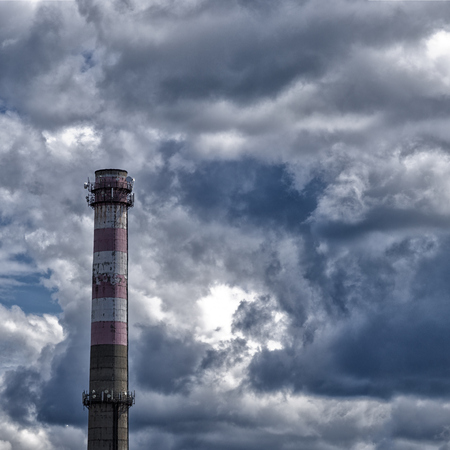Factory pipe against the cloudy skyの写真素材