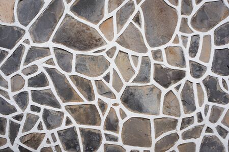 Wall of stones with white cement streaks, natural textureの写真素材