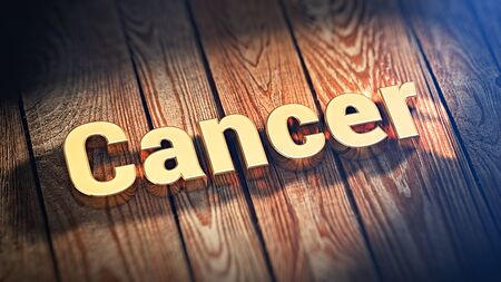 The word "Cancer" is lined with gold letters on wooden planks. 3D illustration imageの写真素材