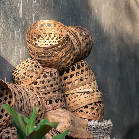Heap of traditional balinese wattled baskets near the grey wall, Bali, Indonesia.の写真素材