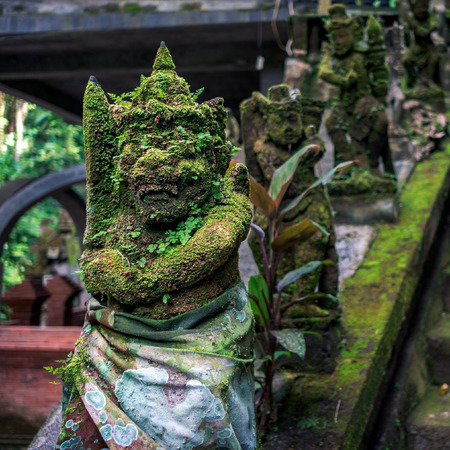 Moss-grown sculptures of balinese creatures in the temple on Bali, Indonesia