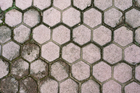 Fragment of old road paved by gray hexagonal tiles.の写真素材