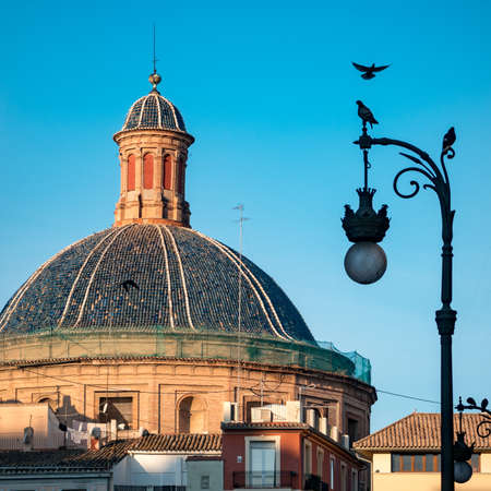 The blue tile dome of the Basilica de la Virgen de los desamparados at sunset. Basilica is located in the historical center of old town in Valencia.の写真素材