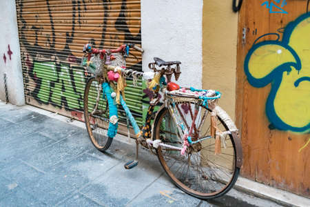 Shabby chic bicycle leaning against the graffiti wall on the street of Valenciaの写真素材