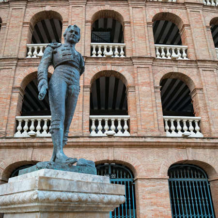 Valencia, Spain - October 29, 2019: Statue of toreador Manolo Montoliu in front of the bullring Plaza de toros de Valencia.のeditorial素材