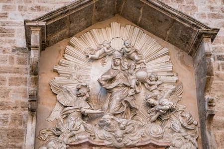 Valencia, Spain - October 27, 2019: central niche of catholic church San Juan del Mercado decorated with a stucco statuary group of the Virgen del Rosario (Virgin of the Rosary) attributed to Jacopo Bertesi.のeditorial素材