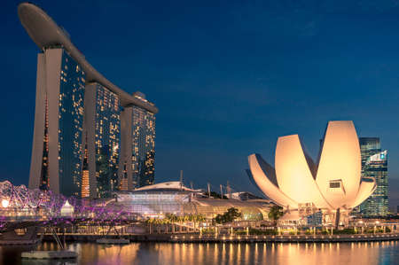 SINGAPORE - SEPTEMBER 15, 2016: Illuminated Artscience museum designed in the shape of lotus flower, The Helix bridge and Marina Bay Sands resort in the evening Singaporeのeditorial素材