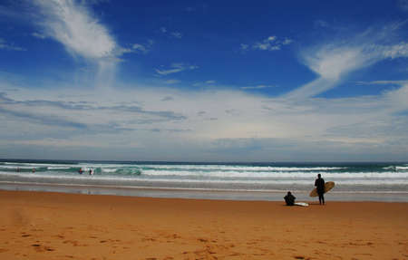 surf beach with surfer waiting for good wavesの写真素材