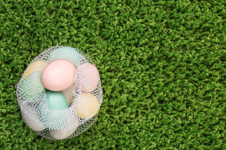 Easter spring eggs on green grass in plastic bagの写真素材