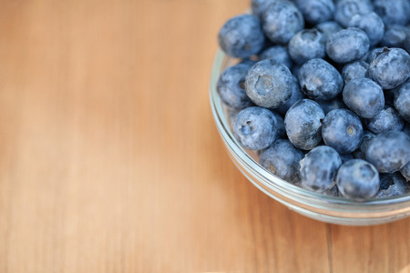 Berries blueberries lying on wooden deck in glass right side space for text