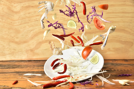 Papaya salad menu splashing on wooden background,Vegetables splashing,Thai food.の写真素材