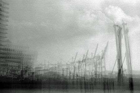 Unreliable black and white analogue photographer of cranes in a harborの写真素材