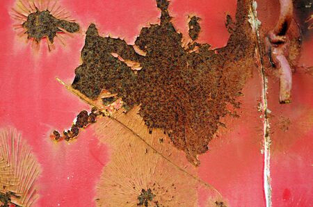 Close up of a rustic red metal plate with rusty and white scratches.の写真素材