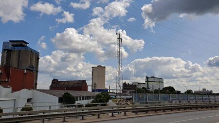 Photograph of an industrial landscape against blue sky. with white clouds.の写真素材