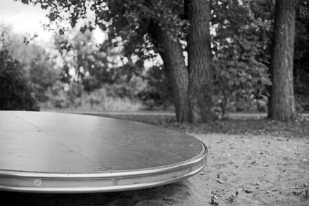 Black and white analog photography of a playground in a park with a great turntable.の写真素材