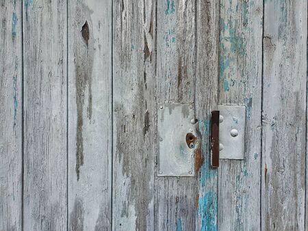 Close up photography of a gray wooden garage door with peeling paintの写真素材